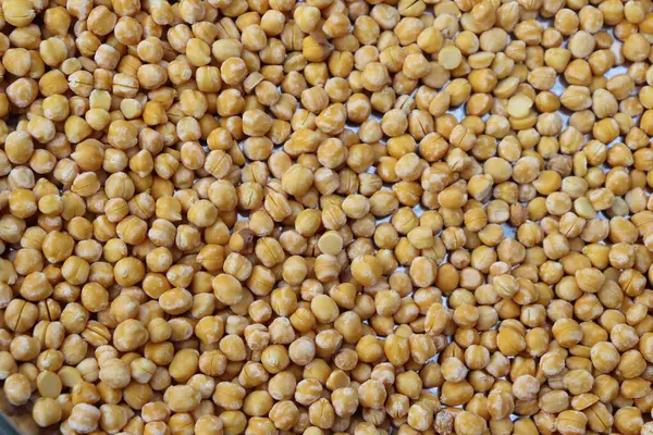 Bu resim pek çok canlı, kurumuş bezelyenin tam bir çerçevesini gösteriyor. Bezelyeler sıkıca paketlenir ve doğal dokuyu vurgulayan dokulu bir arkaplan oluşturulur..