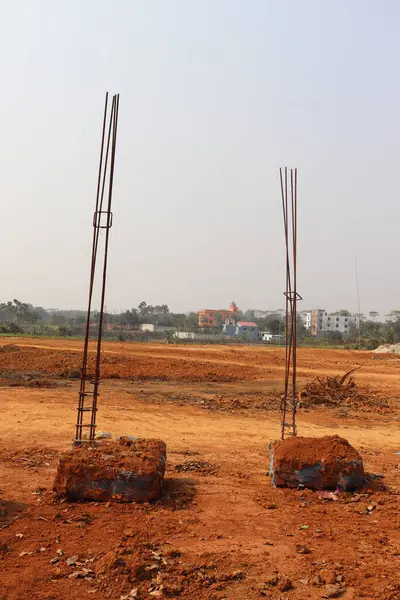 Beton temellerin yer aldığı bu planda inşaat devam etmekte; demir demiri çıkıntıları gökyüzüne doğru, görünür yapılara sahip bir yeryüzü arka planına karşı yapı hazırlığının sinyallerini vermektedir.
