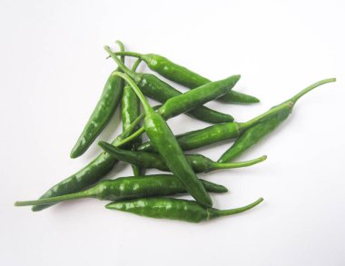 Temiz ve çarpıcı bir görüntü sunan el değmemiş beyaz arka planda sunulan taze, canlı yeşil biber yığını. Bu resim doğal renkleri ve basitliği vurgular..