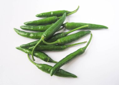 Temiz, beyaz bir yüzeye yığılmış birkaç taze yeşil biberin canlı rengini ve dokusunu yakalamak, bu resim doğal renkleri gösteren bir mutfak malzemesi..