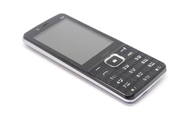 Beyaz bir arkaplanda yakalanan modası geçmiş siyah bir cep telefonu, modern akıllı telefon teknolojilerine geçişin sinyallerini veren sayısal tuş takımını sergiliyor..