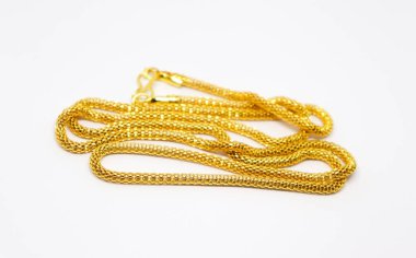 Pırıl pırıl altın zincirli kolyeyle bu resim, karmaşık tasarımı ve zengin rengini temiz beyaz bir zemin karşısında sergiliyor ve büyüleyici bir kontrast yaratıyor..