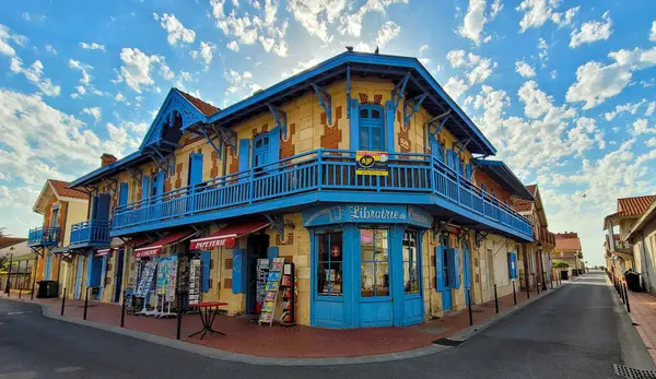 Güzel mavi-sarı Librairie de Corinne, güneşli bir günde beyaz bulutlarla mavi gökyüzünün arka planında. 12 Haziran 2022. 7 Rue Andre Leroux, 33780, Soulac-sur-Mer, Fransa.