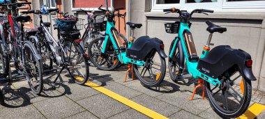 Bisiklet parkında diğer bisikletlerin yanında iki yeşil katlı e-bisiklet duruyor. Mobilitesini İyilik İçin Değiştir. Haziran 08, 2024. Ueberlingen, Almanya