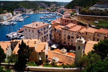 Fransa 'nın güneyindeki Korsika şehrinde güneşli bir günde Bonifacio Limanı' nın yatları ve Hisar manzarası.