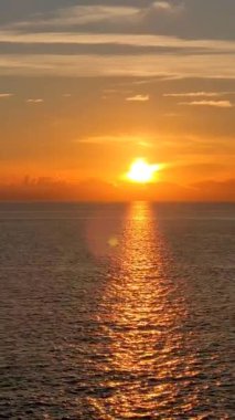 Yumuşak, altın bir gün doğumu ya da denizde, okyanusta ya da gölde gün batımı. Altın romantik anlar. Güneş ışınları suda oynar.