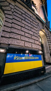 Büyük tarihi bir binanın duvarında StandWithUkrayna etiketli Ukrayna bayrağı. Dünya Ukrayna 'ya yardım ediyor. 22 Aralık 2024. Berlin, Almanya