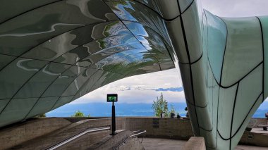 Hungerburgbahn İstasyonu - Innsbruck 'taki hibrit füniküler tren istasyonu. Arka planda Alplerin karla kaplı zirveleri var. Zaha Hadid Mimarlar. 18 Mayıs 2023. Innsbruck, Avusturya