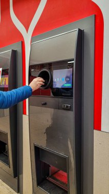 Süpermarket Kaufland 'deki otomatik geri dönüşüm makinesine plastik şişe koyan adamların el görüntülerini kapatın. Para biriktirmeyi. 20 Nisan 2024. Uberlingen, Almanya