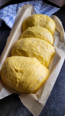 The dough for handmade pumpkin bread in the baking pan with baking paper, on the table, ready for baking. clipart