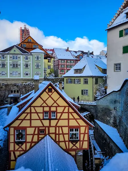 Meersburg 'un harika bir sabah manzarası. Taze beyaz karla kaplı çok renkli ve yarı ahşap evler. Evlerin ön cephesinde - Noel çelenkleri.