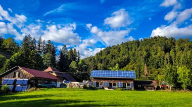 Güneş sistemi ve güneş termal enerji sistemiyle donatılmış bir grup tarımsal ahşap bina. Yakacak odunları olan konteynırlar da yakınlardadır..