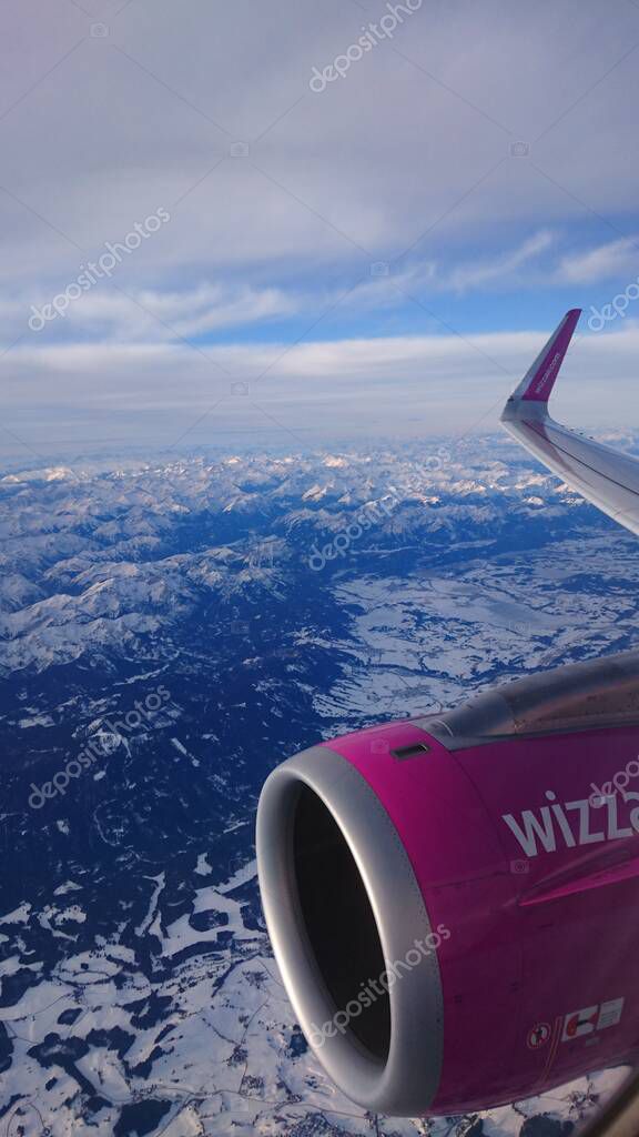 Airplane window view from a Wizz Air plane on picturesque snow-covered Austrian Alps. Travel in the pre-war period. February 26, 2019. Flight Memmingen, Germany - Kyiv, Ukraine.