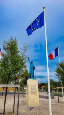Dünyayı Aydınlatan Özgürlük, Fransız bayrağı ve Avrupa Birliği bayrağı yakınındaki Özgürlük Heykeli. 30 Haziran 2023. Soulac-sur-Mer, Yeni Akitanya, Fransa