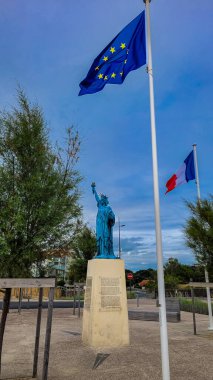 Özgürlük Heykeli, Dünyayı Aydınlatan Özgürlük, Fransız bayrağı ve Avrupa Birliği bayrağı yanında. 30 Haziran 2023. Soulac-sur-Mer, Yeni Akitanya, Fransa