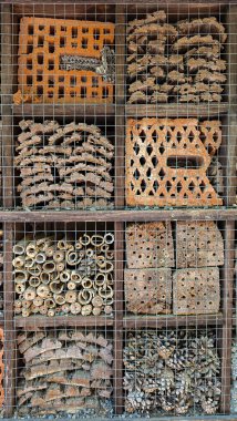 Böcekleri korumak için çeşitli kompartımanları ve doğal dolguları olan böcek oteli. Dikey biçim