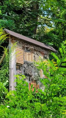 Yağmurdan korunmak için çatısı kiremit kaplı bir bahçe ya da ormandaki böcek oteli. Küçük böcekler için yaşam alanı.