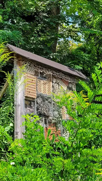 Yağmurdan korunmak için çatısı kiremit kaplı bir bahçe ya da ormandaki böcek oteli. Küçük böcekler için yaşam alanı.