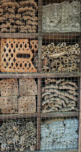 Böcek oteli, böcek oteli ya da böcek evi. Birkaç kutu ve çeşitli dolgu maddeleri var. Böceklere barınak sağlamak için yaratılmış. Dikey biçim.