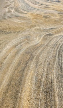 Güzel kum dokuları. Sakin renklerde kumdaki doğal ve güzel dalgalı desen, soyut bir resim olarak kullanılabilir. Dikey biçim.