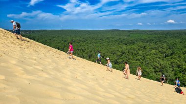 İnsanlar Avrupa 'nın en yüksek kum tepesine, Arcachon Körfezi' ndeki Pilat Kumuluna gidiyorlar. Rastgele insanlarla fotoğraf. 13 Haziran 2025. Grande Dune du Pilat, Landes de Gascogne, Fransa.