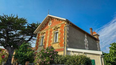 Fransa 'nın şirin Soulac sur Mer kasabasındaki Atlantik Okyanusu' ndaki villanın manzarası. Ön planda pembe çiçekli zakkum var. Tatil köyünün tipik mimarisi..