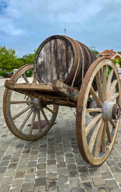 Büyük ahşap tekerlekleri olan eski bir araba üzerinde büyük, eski bir ahşap şarap fıçısı. Seçici odak