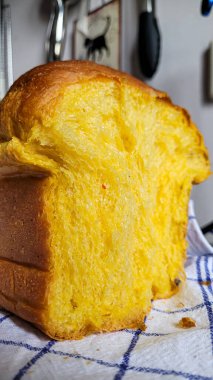 İştah açıcı el yapımı balkabağı ekmeğinin yarısı beyaz mavi bir mutfak havlusunda.