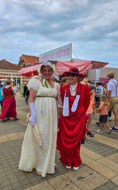 Belle Epoque kostümlü iki bayan yıllık Soulac festivalinde poz veriyor. 7 Haziran 2025. Soulac-sur-Mer, Fransa.