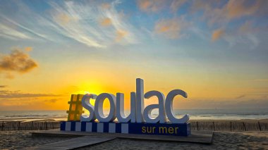 Hashtag of Atlantic town Soulac-sur-Mer, giant letters on a beach on the background of sunset sky. June 6, 2025. Soulac-sur-Mer, Medoc. France.