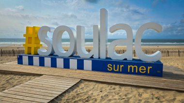 View of the hashtag Soulac-sur-Mer, giant letters on a beach on the background of blue sky with clouds. June 4, 2025. Soulac-sur-Mer, Medoc. France.