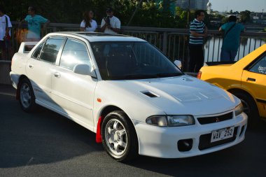 PASIG, PH - APR. 21 - Mitsubishi Lancer evrimi 21 Nisan 2024 tarihinde Filipinler 'in Pasig şehrinde Angie King ile buluştu. Angie King bir araba meraklısı ve Filipinler 'de bir araba yarışması düzenledi..