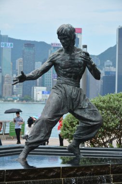 TSIM SHA TSUI, HK - 28 Mayıs - Bruce Lee heykeli 28 Mayıs 2024 tarihinde Tsim Sha Tsui, Hong Kong 'da. Bruce Lee heykeli, Hong Kong 'daki Yıldız Bulvarı' nda bulunan bronz bir anıttır..