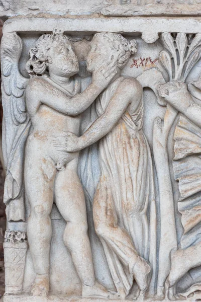 在大理石墙上雕刻的石雕上的特写 这些石雕代表了一个赤身裸体的男天使和一个正在接吻的女孩 — 图库照片