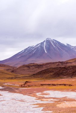 Atacama Çölü 'ndeki Piedras Rojas parkında karlı volkanik tepeli bir vadi.