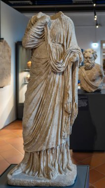 İtalyan müzesinde sergilenen mermerde klasik Roma heykelinin başsız kalıntılarına yakın plan.