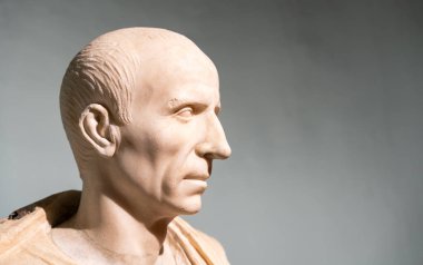 Close-up on ancient marble statue portraiting the profile of a senior bald roman man clipart