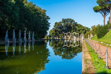 İtalya parkındaki gölet antik Roma heykelleri ve mermer sütunlarla süslenmiş.