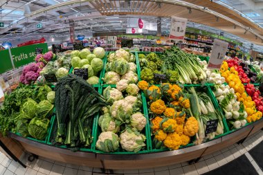 Cuneo, İtalya - 22 Kasım 2022: Spazio Conad süpermarketinde çeşitli renkli lahana, karnabahar, sebze ve biberli tezgah, balık bakışı