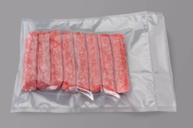 Raw turkey and pork meat sausage in vacuum packed sealed for sous vide cooking isolated on Gray background in top view