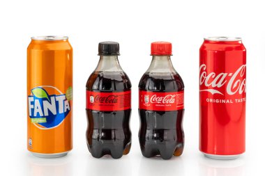 Italy - january 14, 2023: 500 ml Can of Coca Cola original taste with can of Fanta Original soft drink with orange juice and 330 ml Coca Cola pet bottles isolated on white, clipping path. 