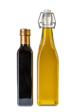 Extra virgin olive oil in glass bottle with airtight cap with snap closure next to vinegar bottle isolated on white, clipping path