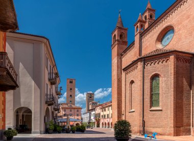 Alba, Langhe, Piedmont, İtalya - 16 Ağustos 2022: Duomo Meydanı manzarası güzel gökyüzü altında eski evler ve ortaçağ kuleleri arasında belediye binası 