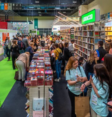 Torino, İtalya - 22 Mayıs 2023: Raflar arasında 35. Turin Uluslararası Kitap Fuarı 'nda kitapları sergilenen ziyaretçiler. 