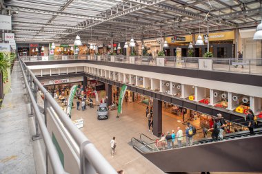 Torino, İtalya - 22 Mayıs 2023: yenilenmiş eski Fiat araba fabrikasındaki Lingotto Torino alışveriş merkezinde yürüyen merdiven ile kapalı pavyon