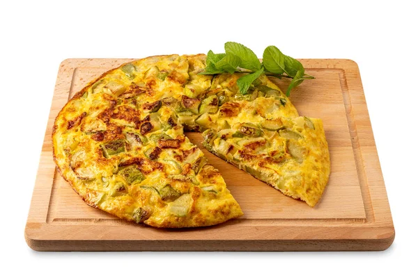 stock image Omelet with zucchini with leaves and of mint, whole omelet with cut slice on wooden cutting board isolated on white with clipping path included 