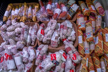 İtalya - 31 Mayıs 2023: İtalyan salamı hasır sepetlerle İtalyan süpermarketinde satılığa çıkarıldı