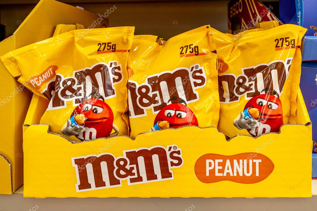 Italy - July 13 2023: M and Ms Peanut candy yellow packages in branded cardboard box on sale on the shelves of an Italian discount store