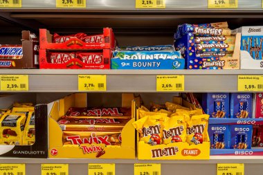 İtalya - 13 Temmuz 2023: KitKat ve Bounty şekerleri, Smarties ve M ve Ms Peanut şekerleri ve Bisco paketleri bir İtalyan indirim mağazasının raflarında satılan karton kutularda sergileniyor
