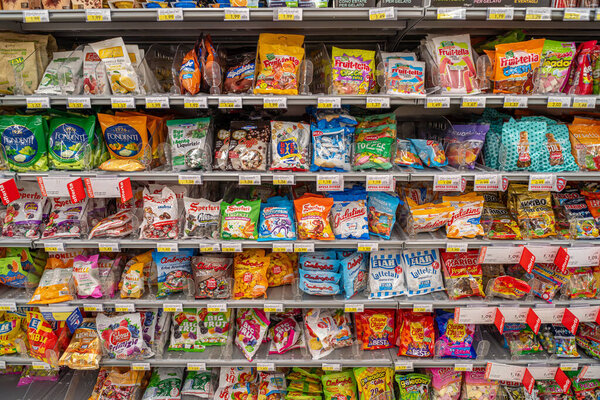 Italy - July 17, 2023: Candies of various types and brands in packets for sale on Italian supermarket shelves
